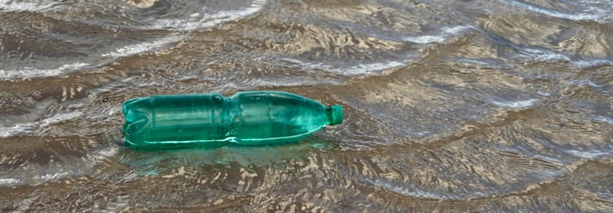 Green plastic bottle floating on water