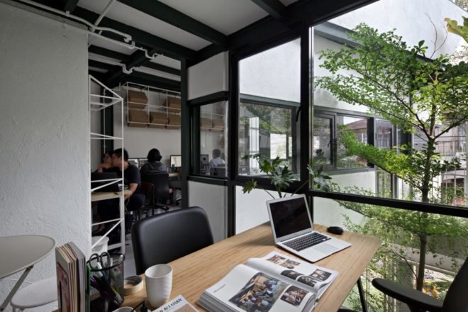 Light wood desk and several windows in the home office