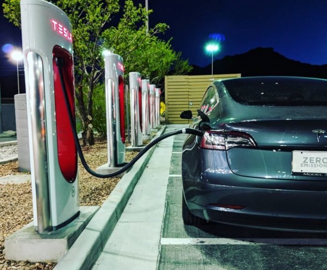 Tesla electric car charging at a station