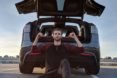Nico Nevolo sitting in front of the open trunk of his Tesla Model X