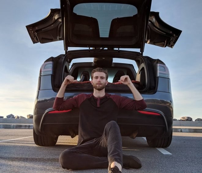 Nico Nevolo sitting in front of the open trunk of his Tesla Model X
