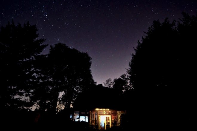 a night shot of a home with trees in the background