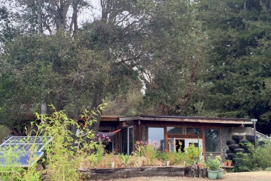 a home in the forefront with a forest in the background