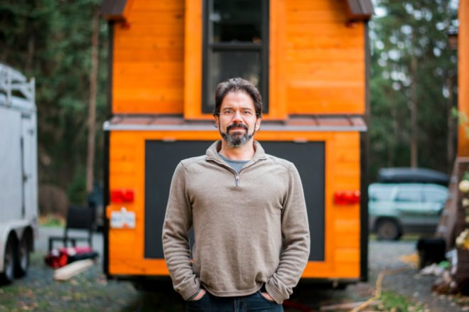 man standing in front of a tiny home
