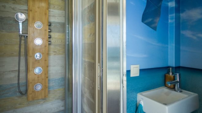 A small bathroom with a shower and sink.