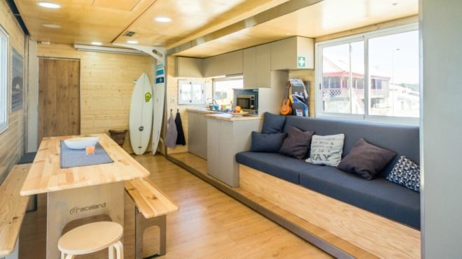 A living room and kitchen with a couch and benches.
