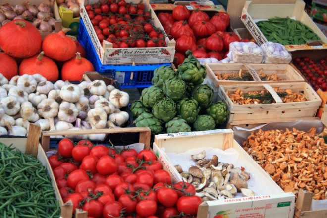 tomatoes, garlic, artichokes, and mushrooms in produce boxes