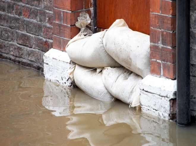 Sandbag barrier in doorway of flooded street in York