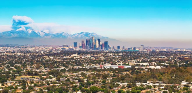 Smoke from forest fire rising behind LA skyline