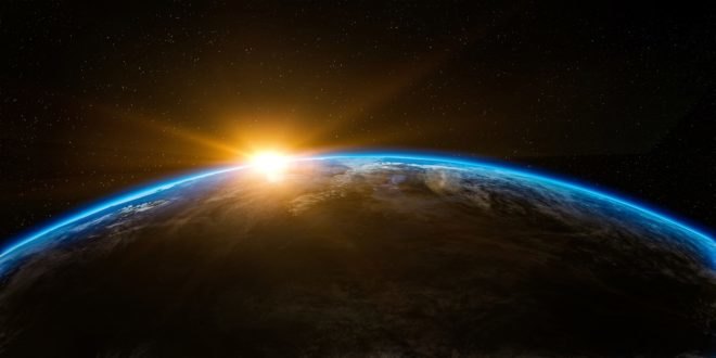 The sun rises over Earth as seen from outer space