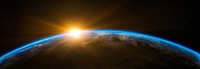 The sun rises over Earth as seen from outer space