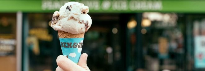 A hand holding a Ben & Jerry's ice cream cone