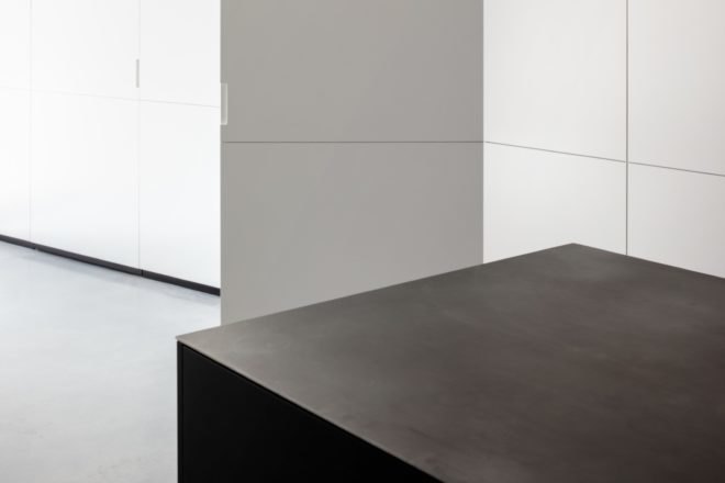 minimalist black kitchen island and opening wall panels