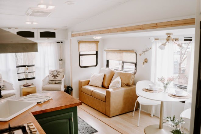 white interior space with tan loveseat and dining area