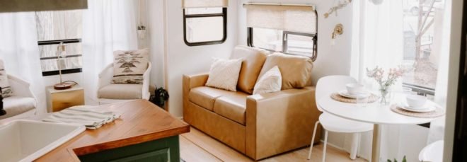 white interior space with tan loveseat and dining area