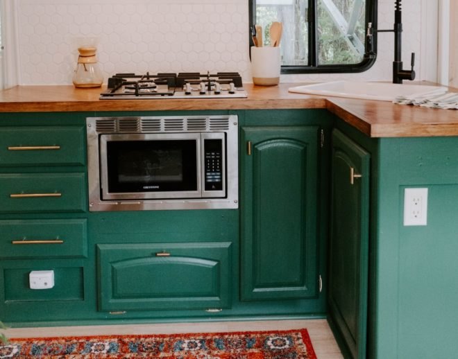 a kitchen with green cupboards