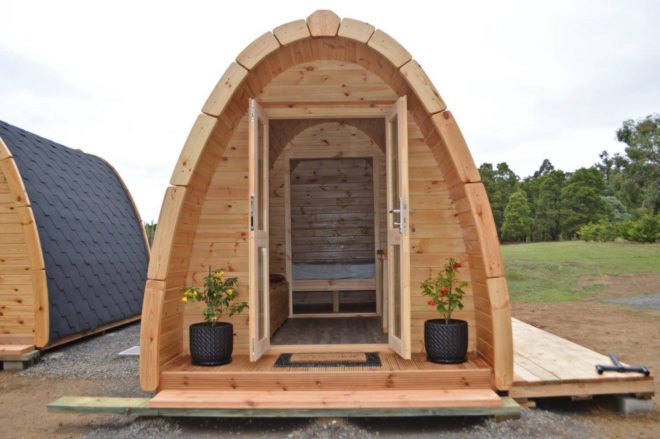 a curved wooden cabin with open doors