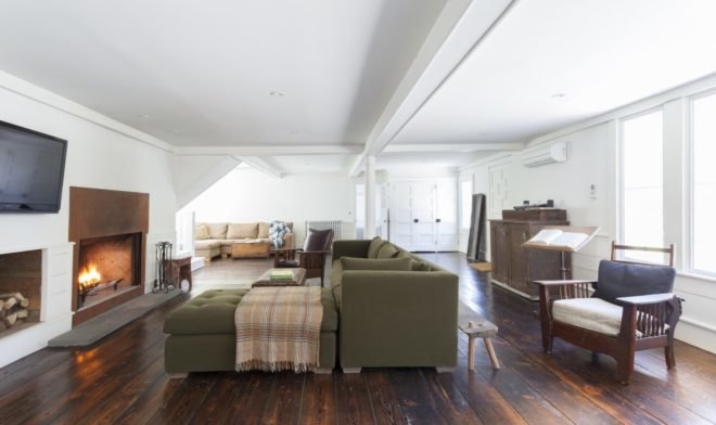 living room with dark green couch facing a fireplace