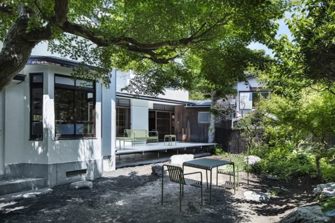 green tables and chairs on veranda surrounded by greenery