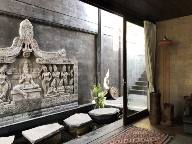 stone carving and stepping stones in a small pond