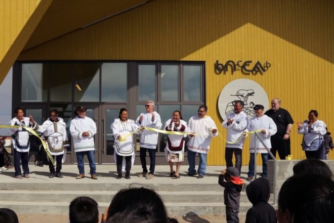 inuit citizens gather on the front steps of a cultural center