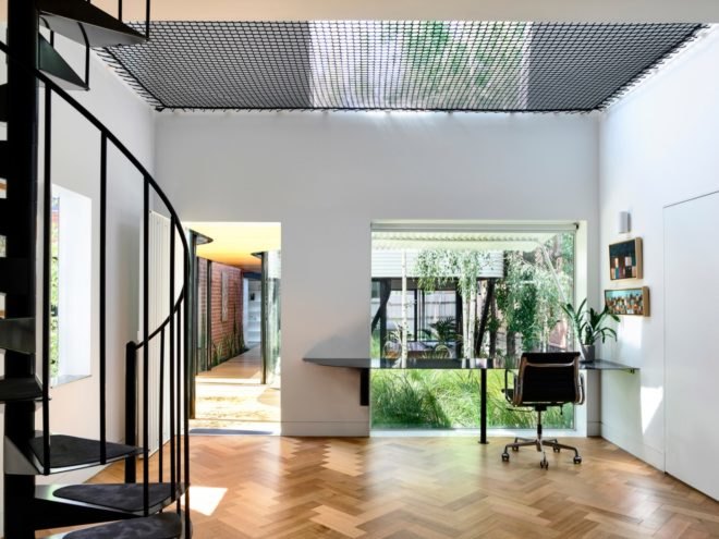 Desk facing large glass window with views of the garden