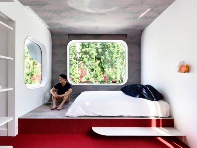 Bedroom with large windows and red floors