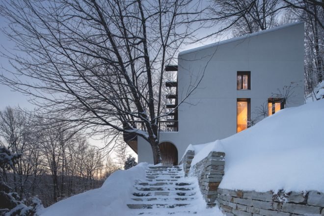 side view of a white chalet in a snowy forest