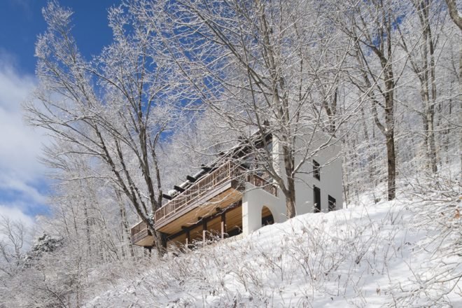 view of a canadian chalet in snowy forest