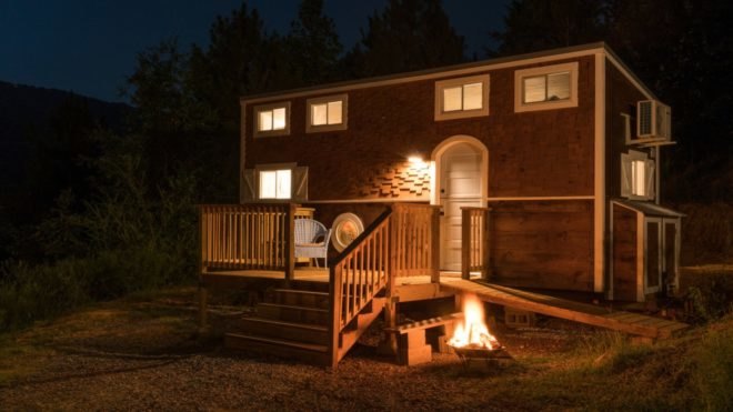 nighttime photo of tiny home with front porch