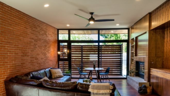 a seating room with all glass wall and ceiling fan