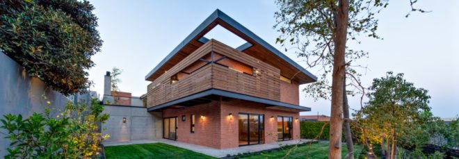 a large brick home with wooden shading