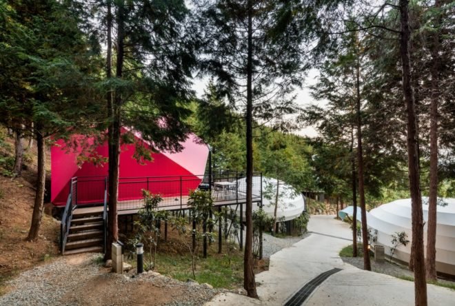 a walking path leading to a pink camping pod