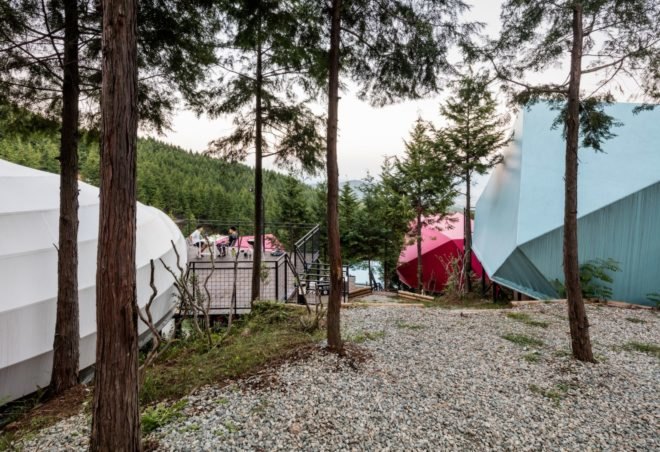 a walking path in front of various camping pods