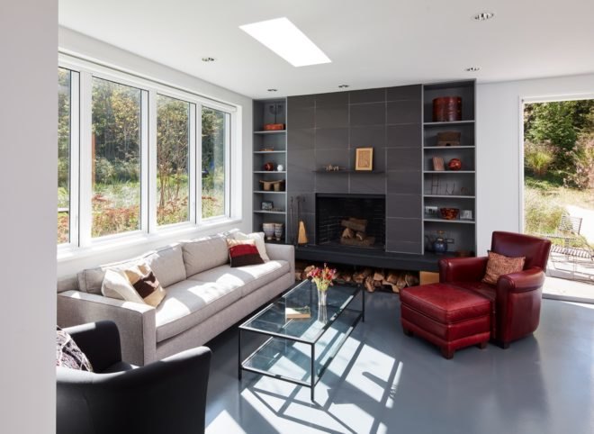 Living room with white couch, red chair, and dark gray fireplace