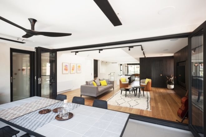 common area with large dining table, a gray couch, tan and white chairs and dark coffee tables