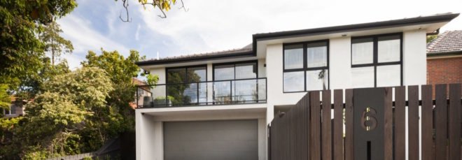 White multistory home with upstairs balcony