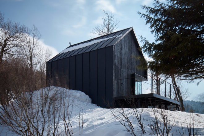 Black cabin in a snowy landscape
