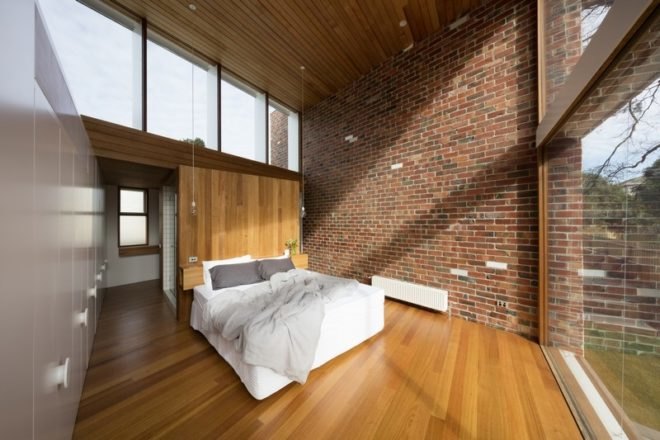 Bedroom with exposed brick wall and wood floors.