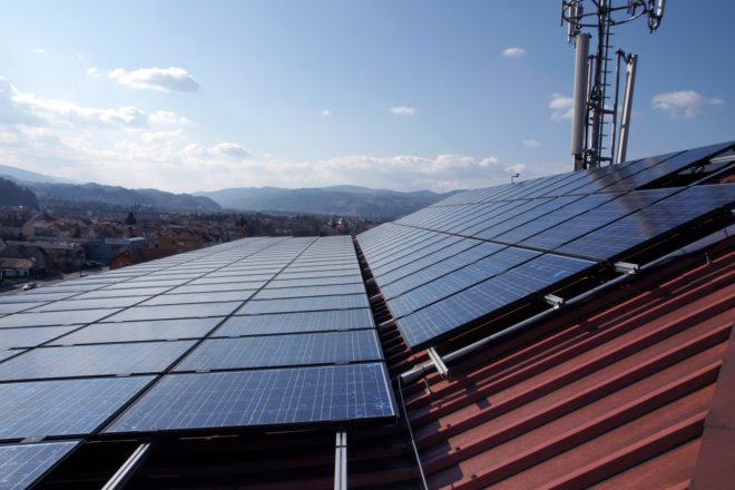 Solar panels on a roof with mountains in the distance