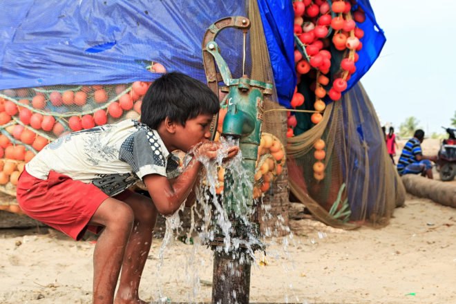 Child drinks water from an outdoor water spout