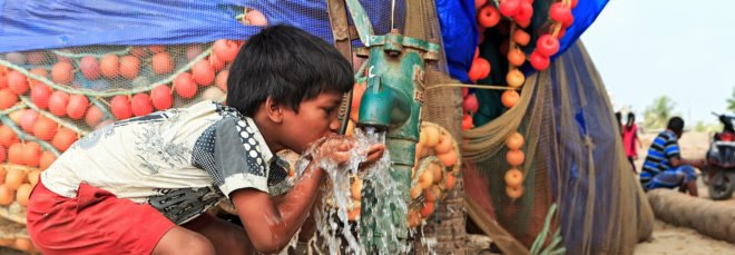 Child drinks water from an outdoor water spout