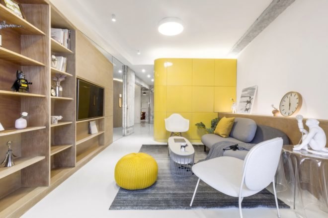 living room with timber entertainment center, gray couch, large yellow cube in background