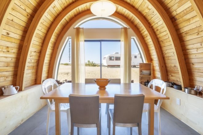 dining room with curved wood ceilings and views of the desert