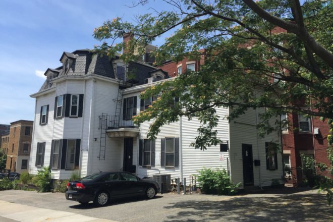 Before photo of the building which was white with black shutters and doors