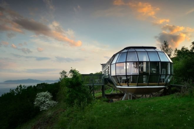 a glass pod surrounded by greenery