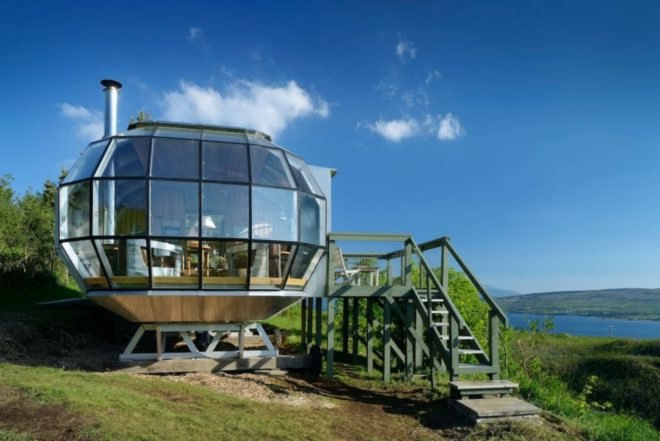 a structure with a glass wall and wooden deck