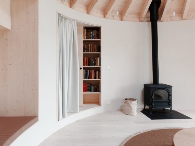 black wood-burning stove next to a doorway partially concealed with a curtain