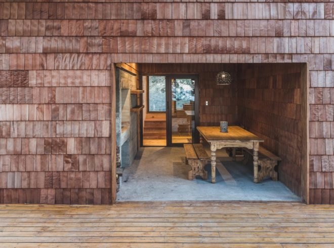 a wooden deck leading into an interior space with a table