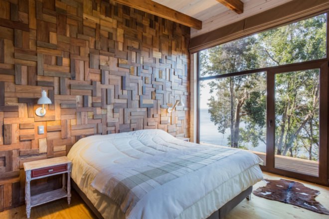 a bed in front of a wooden wall